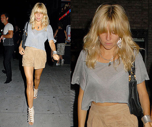 Sienna Miller Wearing Tan Suede Shorts, Gray Cropped Tee, and Buckle Wedges