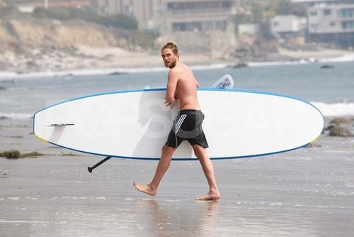 Robert Pattinson carried his paddleboard shirtless.
Robert Pattinson carried his paddleboard shirtless.