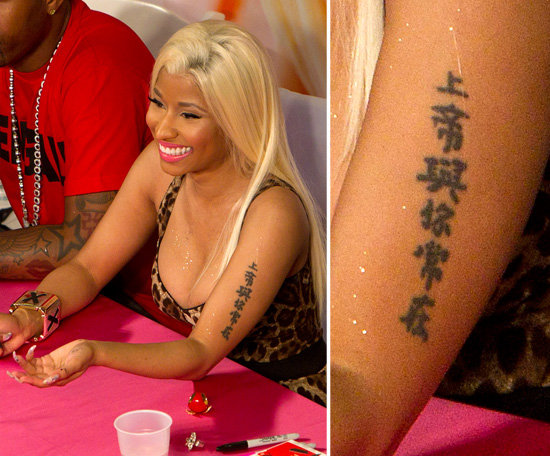 Nicki Minaj has characters running up her arm.
Nicki Minaj has characters running up her arm.