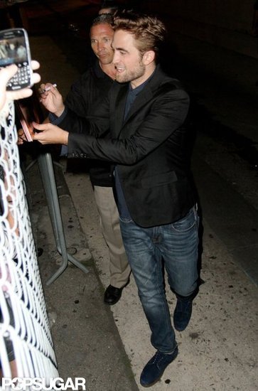 Robert Pattinson smiled and signed autographs for fans. Robert Pattinson smiled and signed autographs for fans.