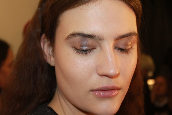 "I'm creating a ray of light on the eye with a metallic strip in a cold nude color right in the middle," makeup artist Tom Pecheux explained. To get a rectangular shadow shape on the eye, he used three different shimmer shadows blended together: Estée Lauder Color Instant Intense Eye Shadow Trios in Smoked Chrome, Steel Lilacs, and Sterling Plums. "Makeup today is very minimal. The inspiration is based on a comfortable, homey, casual indoor place," he said.
"I'm creating a ray of light on the eye with a metallic strip in a cold nude color right in the middle," makeup artist Tom Pecheux explained. To get a rectangular shadow shape on the eye, he used three different shimmer shadows blended together: Estée Lauder Color Instant Intense Eye Shadow Trios in Smoked Chrome, Steel Lilacs, and Sterling Plums. "Makeup today is very minimal. The inspiration is based on a comfortable, homey, casual indoor place," he said.