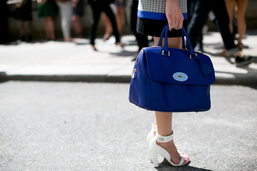 Bold blue on her bag, sleek white on her heels.
Bold blue on her bag, sleek white on her heels.
