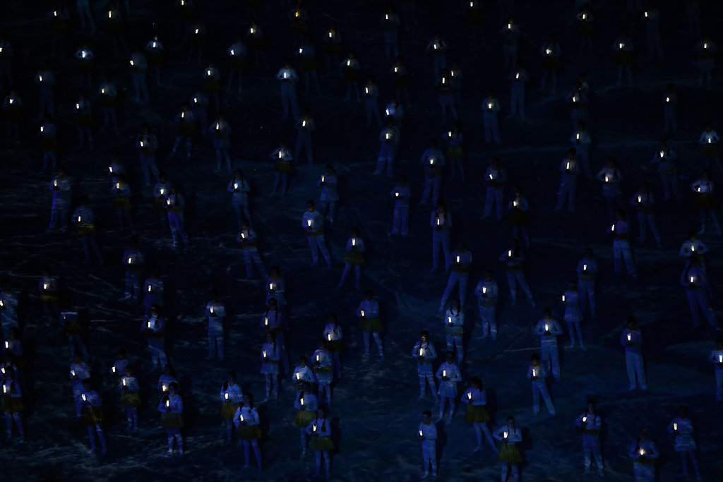 Performers held up lights, as the mascots came in.
