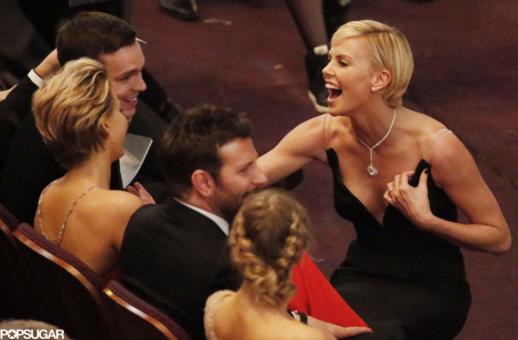 Charlize Theron cracked up while chatting with Jennifer Lawrence and her boyfriend, Nicholas Hoult, in the front row.
Charlize Theron cracked up while chatting with Jennifer Lawrence and her boyfriend, Nicholas Hoult, in the front row.
