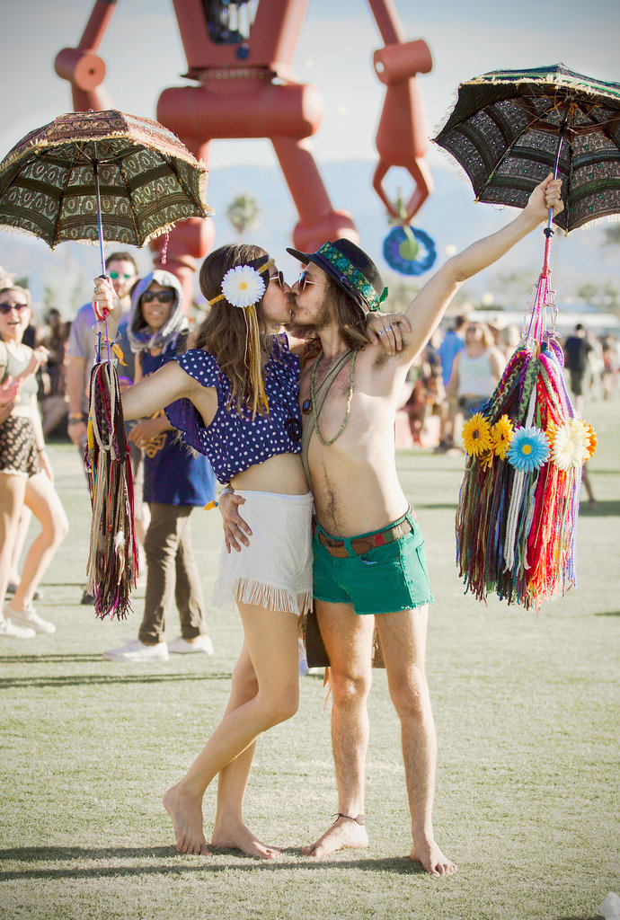 A Coachella couple kissed while holding umbrellas.
A Coachella couple kissed while holding umbrellas.