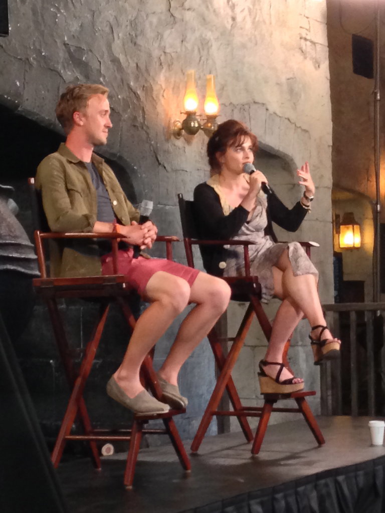 Tom Felton and Helena Bonham Carter, who play villains Draco Malfoy and Bellatrix Lestrange, answered questions during a panel. The two are far from villainous in their real lives. In fact, Helena shared that her two children (with partner Tim Burton), Billy and Nell, were "enchanted" with Diagon Alley. She added that Nell, who's 6, just started reading the first book.
Tom Felton and Helena Bonham Carter, who play villains Draco Malfoy and Bellatrix Lestrange, answered questions during a panel. The two are far from villainous in their real lives. In fact, Helena shared that her two children (with partner Tim Burton), Billy and Nell, were "enchanted" with Diagon Alley. She added that Nell, who's 6, just started reading the first book.