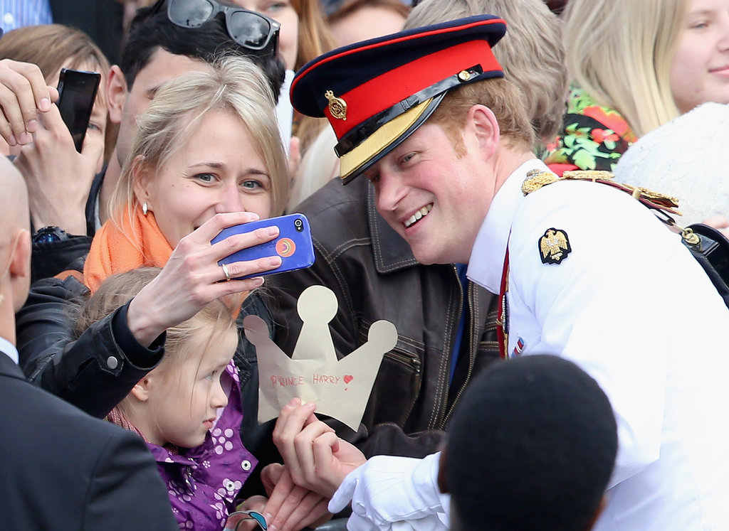 In May 2014, Prince Harry paused to take a selfie with a young woman in Estonia.<br />
