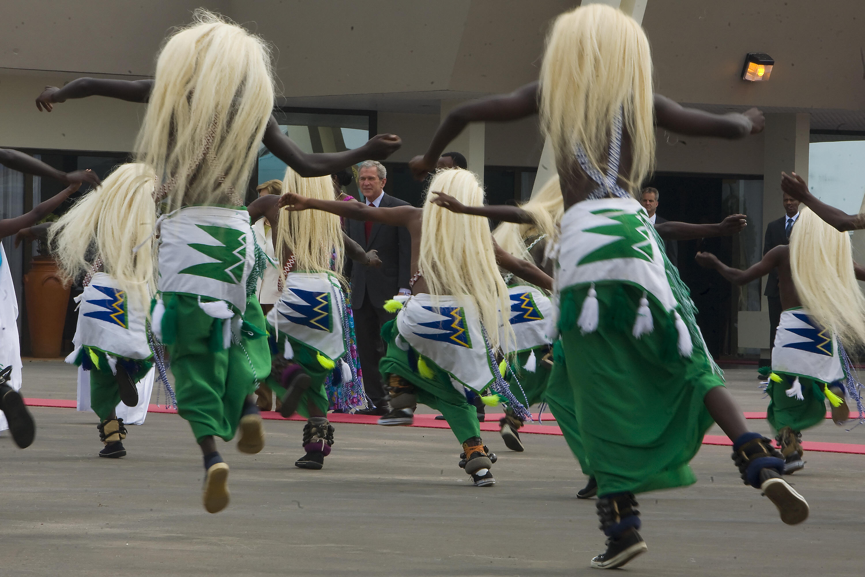 Dancers greet Bush when he arrives at the airport in Rwanda. Dancers greet Bush when he arrives at the airport in Rwanda.
