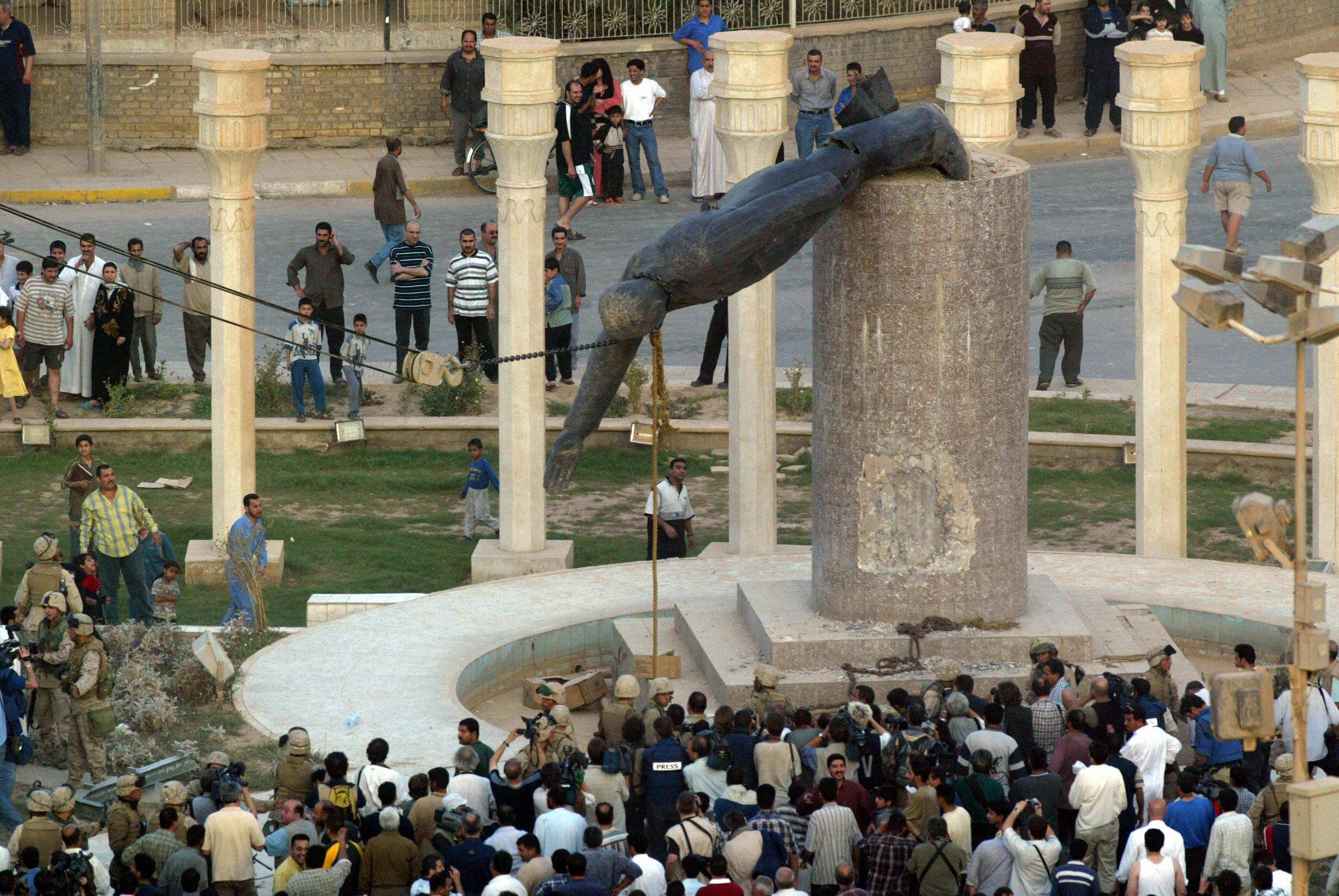 Iraqis watch a statue of Iraqi President Saddam Hussein falling in Baghdad. April 9, 2003. Iraqis watch a statue of Iraqi President Saddam Hussein falling in Baghdad. April 9, 2003.