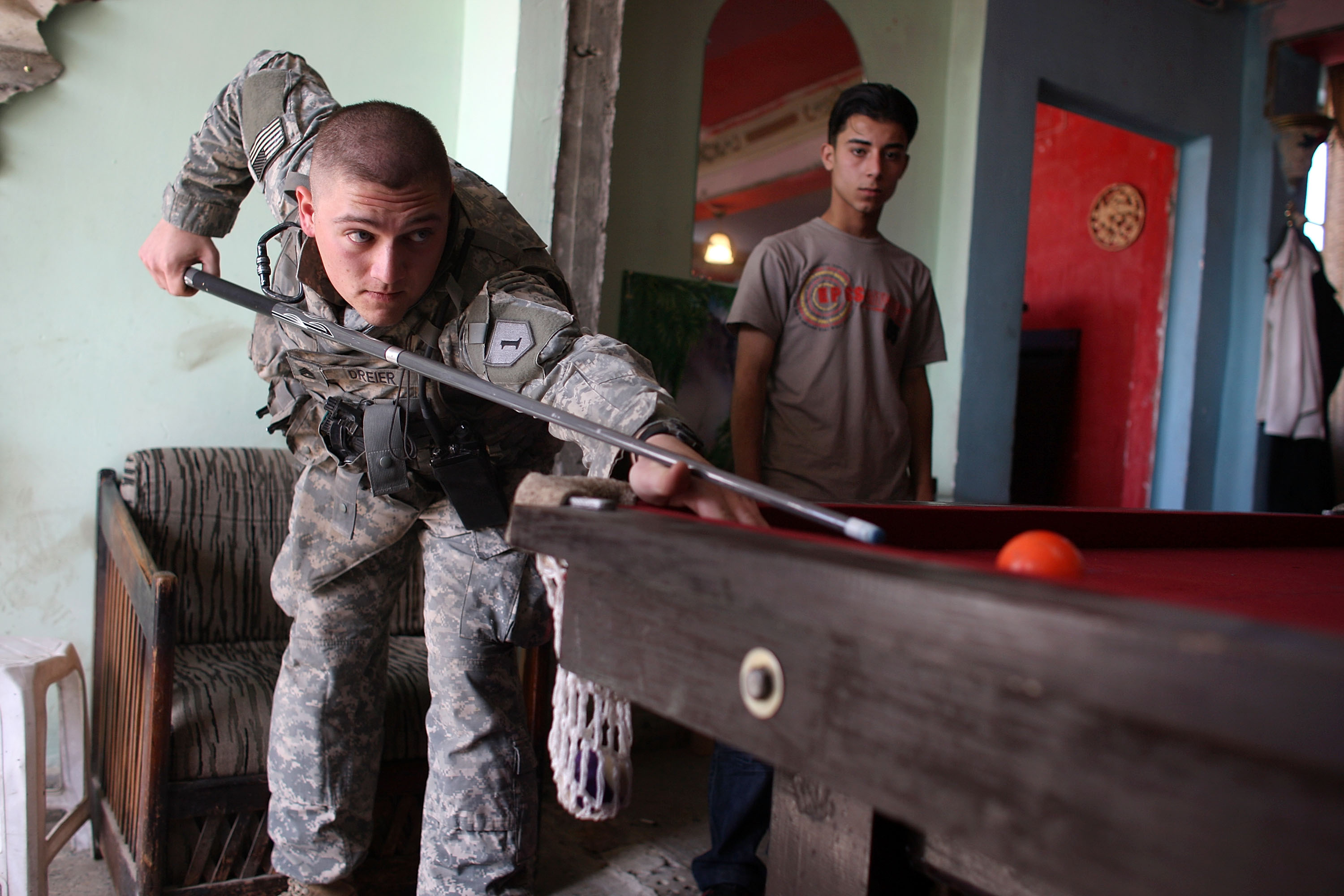 Staff Sgt. Shelby Dreier, from Fawcett, Missouri plays a game of pool at the Doura Guys Cafe while on patrol, March 7, 2008. Staff Sgt. Shelby Dreier, from Fawcett, Missouri plays a game of pool at the Doura Guys Cafe while on patrol, March 7, 2008.