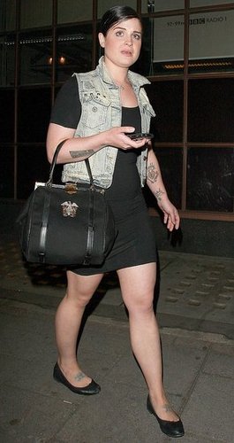 Kelly Osbourne in a Denim Vest Carrying a Top Handle Handbag