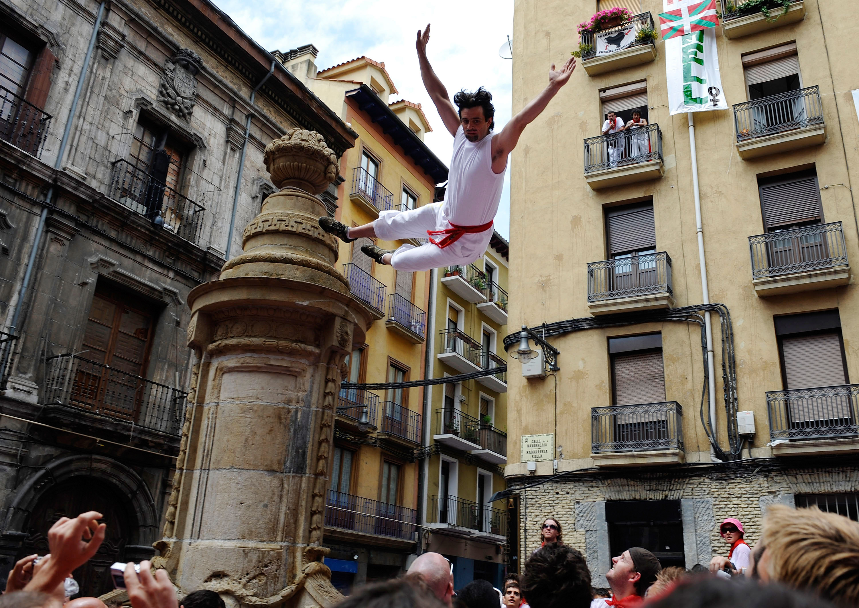 A young reveler jumps from a statue. A young reveler jumps from a statue.