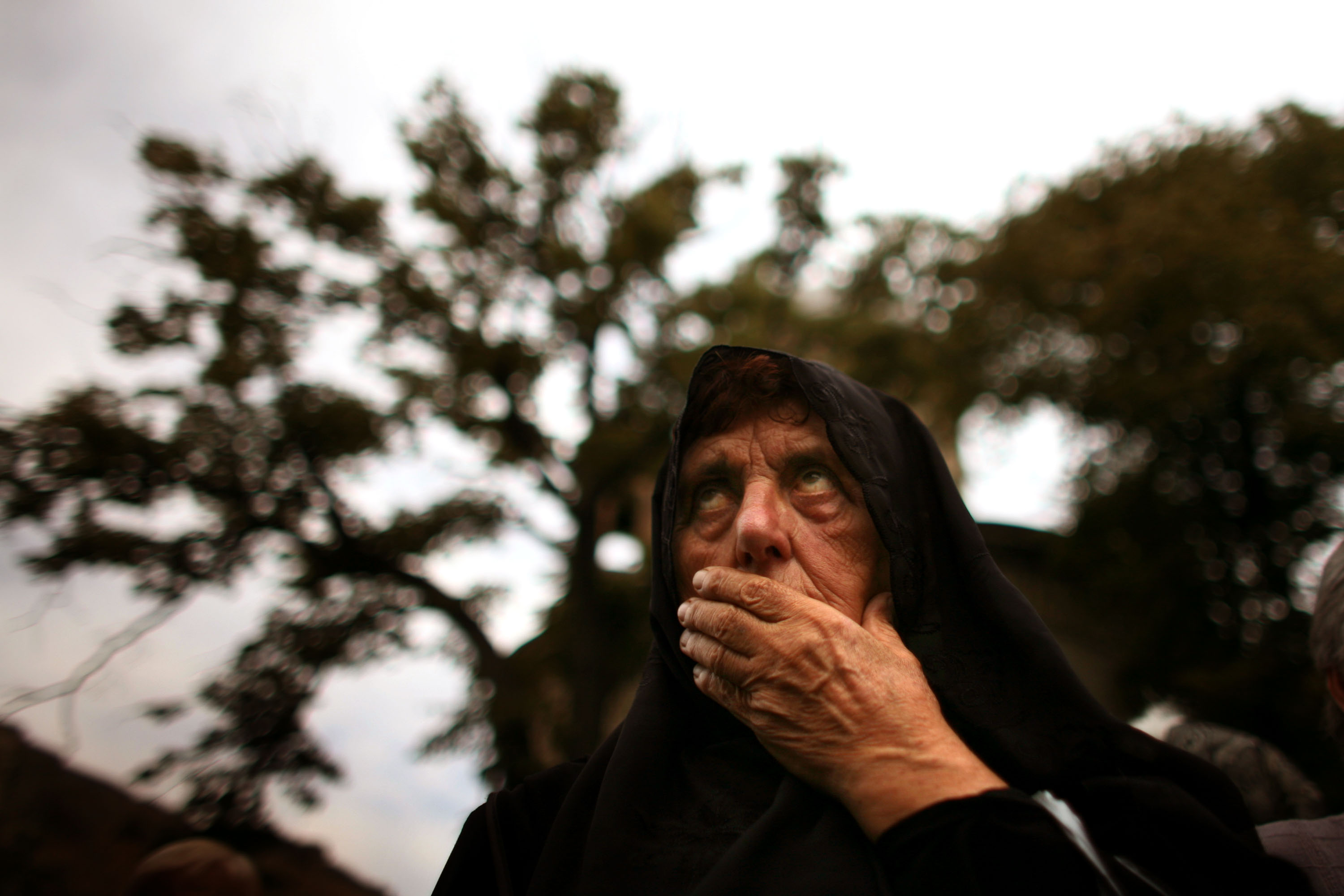 A Georgian woman waits for bread as it's distributed outside a church. A Georgian woman waits for bread as it's distributed outside a church.